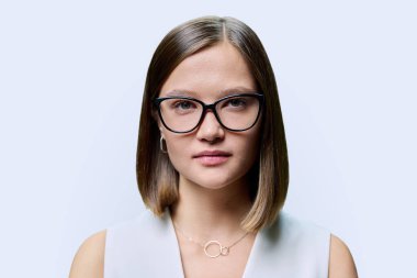 Gözlüklü güzel bir kadının portresi, beyaz stüdyo arka planında doğal makyaj stili olan kadın yüzü. Güzellik bakımı saç, iş eğitimi moda, sağlık vizyonu