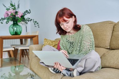 Genç bir bayan evdeki kanepede dizüstü bilgisayar kullanarak oturuyor. Üniversite öğrencisi, blog yazarı, daktilo yazarı, serbest çalışan, boş zamanlarında iletişim öğrenen biri.