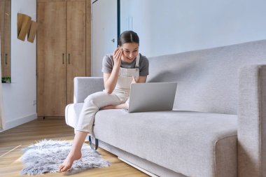Kanepede oturan genç bir kız dizüstü bilgisayardaki webcam 'e bakıp duygusal konuşmalar yapıyor, görüntülü sohbet görüşmesi yapıyor. Boş zaman iletişimi, modern yaşam tarzı, ergenlik kavramı öğrenme teknolojisi
