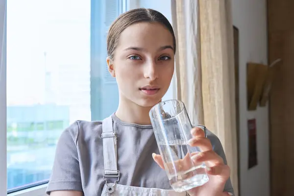 Stock image Close-up of teenage girl drinking water from glass, at home. Healthy lifestyle, health care, food, beauty concept