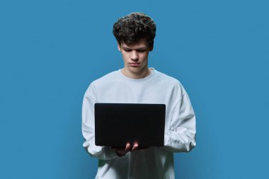 Laptop mavisi stüdyo geçmişi kullanan genç bir üniversite öğrencisi. Kendine güveni olan ciddi bir adam ekrana bakıyor. İnternet teknolojileri, çevrimiçi öğrenim istirahatı, sanal uzaktan eğitim eğlence iletişimi