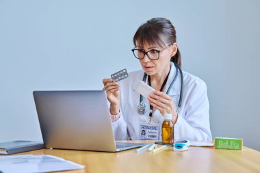 Mature woman doctor using laptop for online consultation video call chat conference, remote meeting of medic and patient, online help, recommends suspension. Health care telemedicine health technology