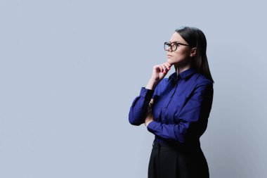 Profil görüntüsü, ciddi iş kadını portresi gri stüdyo arka planında, kendine güveni tam bir kadın reklam bilgisi metniniz için boş yere bakıyor, resim alanı kopyalayın