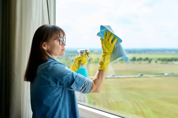 Frau Mittleren Alters Handschuhen Mit Sprühputzfenstern Hause Hausreinigung Hausaufgaben Hauswirtschaft — Stockfoto