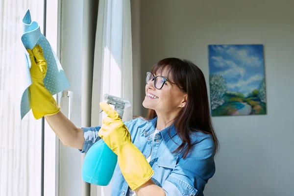 戴手套的中年妇女 家里有喷雾式清洁窗 家庭清洁 打扫房屋 家庭生活 生活方式概念 — 图库照片
