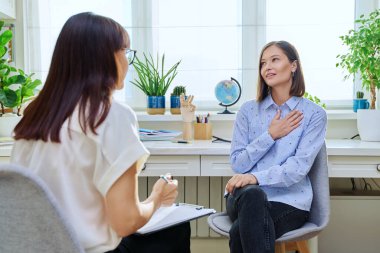 Terapi seansında genç bir kadın terapist ofisinde kadın psikologla konuşuyor. Gülümseyen kadın hasta, profesyonel danışman, psikoterapist, zihinsel sağlık gençliği konsepti