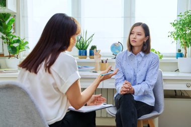 Terapi seansında genç bir kadın terapist ofisinde kadın psikologla konuşuyor. Ciddi kadın hasta, profesyonel danışman, psikoterapist, zihinsel sağlık gençliği konsepti