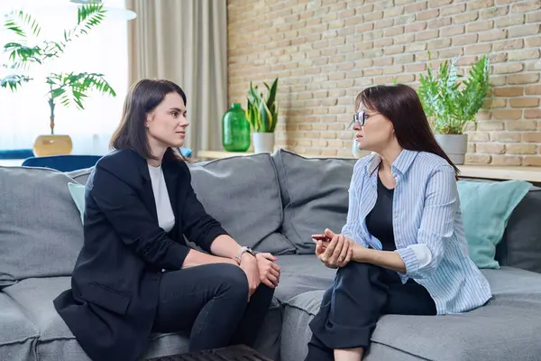 Ofiste konuşan ve tartışan iki iş kadını. Kanepede oturan bayan meslektaşlar. Takım çalışması insanların iş kavramı