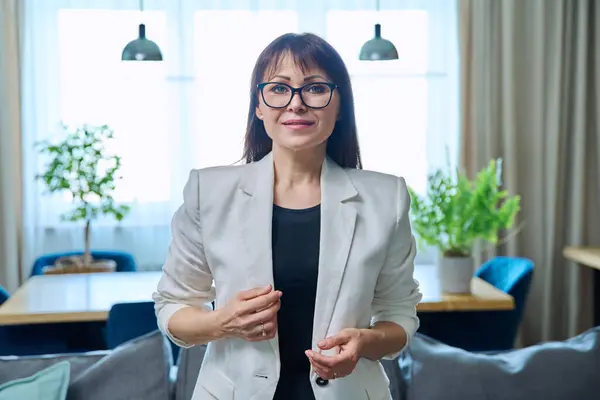 Portrait of business elegant middle-aged woman in office. Confident successful female looking at camera in home office. Job service leadership career control management administration mature people