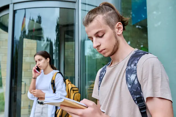 希斯特小伙子 18岁 19岁 背着背包笔记本站在室外 教育建筑背景 生活方式概念 — 图库照片