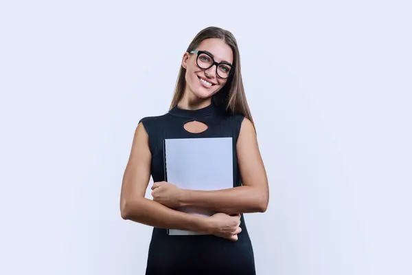 Young business woman with clipboard looking at camera on white studio background. Smiling fashionable confident female worker businesswoman wearing glasses. Business, work, job, executive, occupation