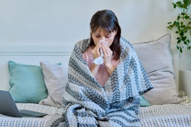 Hapşıran ve peçeteye öksüren hasta, olgun bir kadın. Mevsimsel soğuk algınlığı, mevsim nezlesi, sağlık insanları konsepti