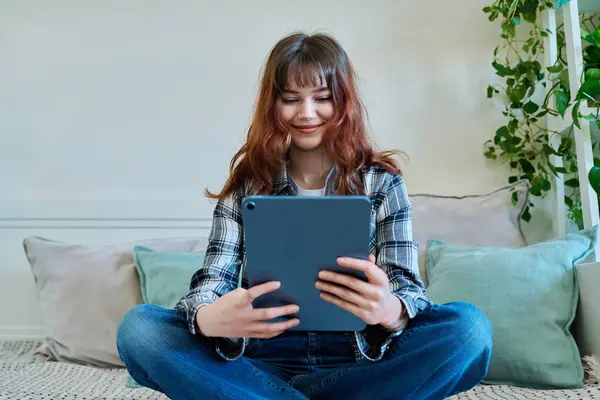 コミュニケーションレジャーのフリーランスを勉強するためのデジタルタブレットを使用して 若い魅力的なトレンディな女子大学の学生は 自宅でソファーに座っています テクノロジー ライフスタイルコンセプト — ストック写真