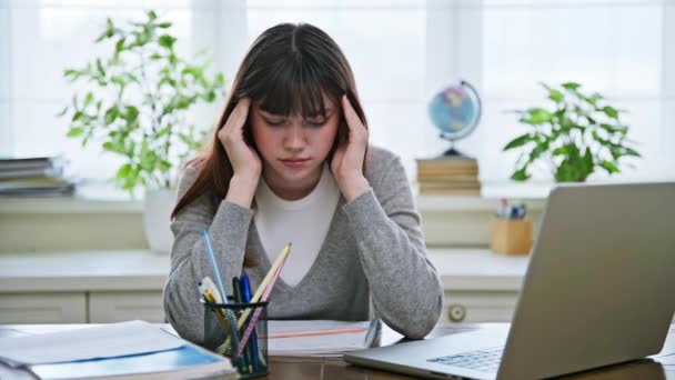 可悲的女大学生坐在办公桌前 手牵着头的太阳穴 带着头疼的电脑 生活方式概念 — 图库视频影像