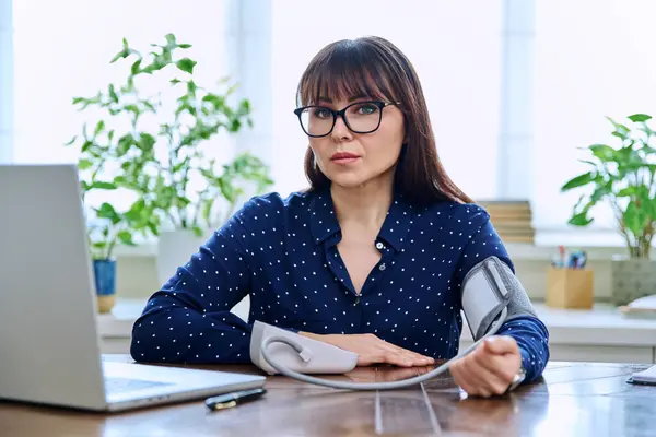 Middle Aged Woman Measuring Her Blood Pressure Sitting Desk Computer — Stock Photo, Image