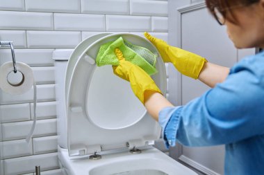 Banyodaki tuvaleti temizleyen koruyucu eldivenlerle yakın plan eller. Hijyen, dezenfeksiyon, temizlik, ev işi, ev temizliği konsepti