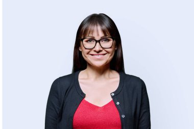 Beyaz arka planda gülümseyen mutlu orta yaşlı bir kadının portresi. Gözlüklü kadın kameraya bakıyor. 40 'ların profesyonel, güzellik sağlık yaşam tarzı iş hizmetleri
