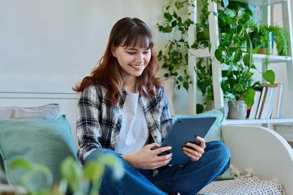 年轻迷人的时尚女大学生坐在家里的沙发上 用数码平板电脑学习交流休闲自由职业 生活方式概念 — 图库照片