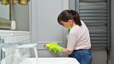 Kadın temizlik yapıyor, mobilyaların tozunu yumuşak kumaşla siliyor, mobilyaların ahşap yüzeylerini cilalıyor. Oda servisi, ev işi, ev temizliği, temizlik hizmeti konsepti.