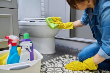Koruyucu eldivenlerle temizlik yapan kadın temizlikçi deterjan profesyonel bez kullanarak tuvaleti temizliyor. Hijyen, dezenfeksiyon, temizlik, ev işi, ev temizliği.