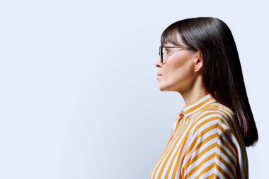 Orta yaşlı ciddi bir kadının profil görüntüsü ileriye bakan, beyaz stüdyo arka planı, reklam metni için kopya alanı. Olgun iş, kendine güvenen başarılı kadın. Pazarlama satış hizmetleri, insanlar