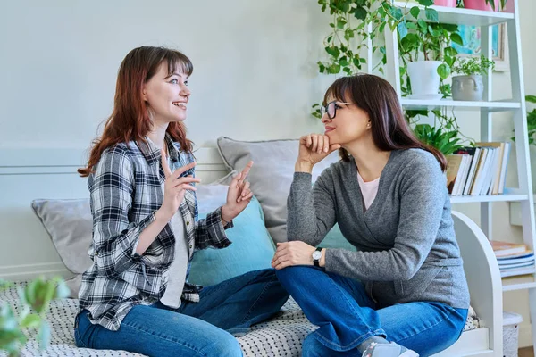 幸せな笑顔の母親と10代の娘が家でソファーに座っている コミュニケーション 20歳の親と娘の関係 — ストック写真