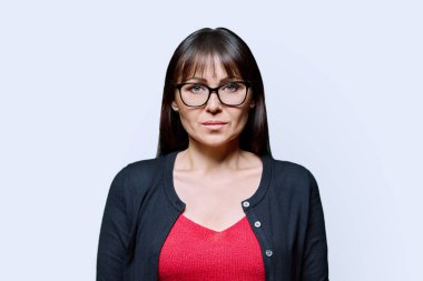 Beyaz arka planda orta yaşlı ciddi bir kadının portresi. Gözlüklü, kameraya bakan kendinden emin bir kadın. 40 'ların profesyonel, güzellik sağlık yaşam tarzı iş hizmetleri