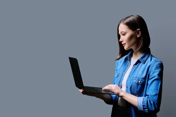 Young Serious Woman Using Laptop Computer Profile View Gray Studio — Stock Photo, Image