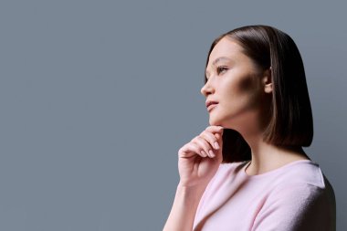 Sağlıklı cilt, saç, gri arka planda doğal makyaj, resim metni için kopyalama alanı olan güzel bir kadının yakın plan portresi. Güzellik modası kozmetik kozmetik tarzı sağlık hizmetleri gençliği