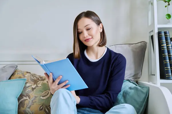 Young Woman Reading Paper Book Relaxed Sitting Sofa Home Fiction Stock Image
