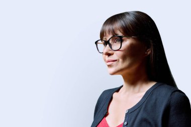 Beyaz stüdyo arka planında gülümseyen olgun kadının profil portresi. Orta yaşlı bir kadın, reklam metni için mekanı kopyalıyor. İş hizmetleri eğitimi, sağlık konsepti