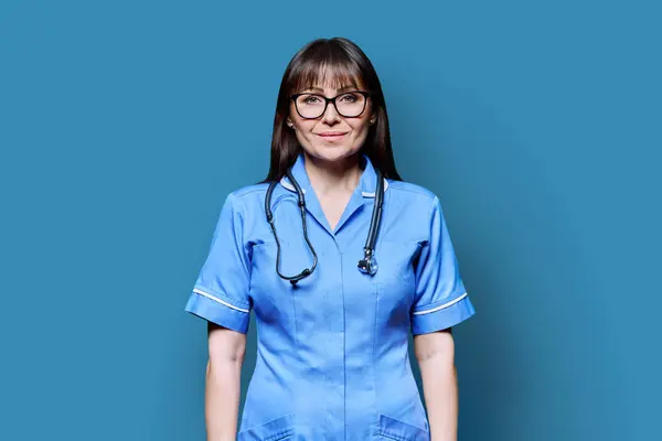 Portret Van Een Glimlachende Verpleegster Van Middelbare Leeftijd Het Blauw — Stockfoto