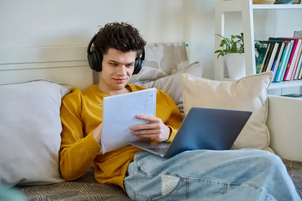 Jongeman Student Koptelefoon Met Laptop Notities Maken Thuis Bank Zitten — Stockfoto