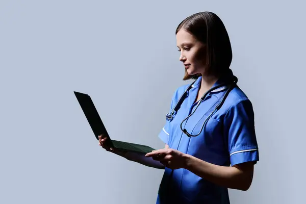 Serieuze Jonge Vrouwelijke Verpleegster Met Behulp Van Laptop Computer Profielweergave — Stockfoto