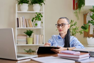 Kendine güveni tam bir iş kadını. İş yerinde oturmuş bilgisayar ekranına bakıyor. Müşteri çalışanı hastasıyla konuşuyor. Uzak iş, teknolojiler, internet, öğretim, blog, iş,