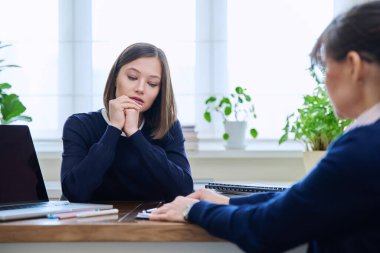 Kadın psikolog sosyal hizmet uzmanı psikoterapist ile seanstaki mutsuz genç kadın hasta. Zihinsel sağlık profesyonel destek tedavisi, stres depresyonu travması