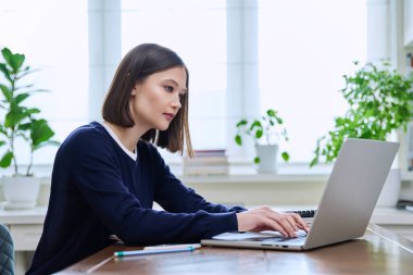 Genç bir kadın bilgisayar laptopunu klavyede yazan, çalışan, ciddi bir genç kız için kullanıyor. Teknoloji, eğitim, eğitim, gençlik kavramı