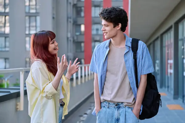 stock image Friends young guy and girl university college students talking together, urban outdoor. Lifestyle, communication, youth 19-20 years old, urban style