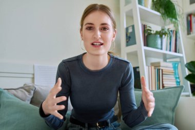 Web kamerasında 16-17-18 yaşındaki bir kızın kameraya, internet toplantısına ve sohbet konferansına baktığı görülüyor. Çekici genç bayan blogger vlog kaydedici evde video kaydediyor