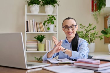 Kadın psikolog zihinsel terapist sosyal hizmet uzmanı uzaktan bilgisayarla çevrimiçi terapi seansı yapıyor. Diz üstü bilgisayara bakıp hastaya psikolojik jestler gösteren bir kadın.