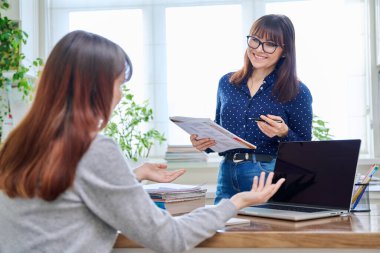 Genç kız öğrencilere dizüstü bilgisayar öğreten öğretmen. Eğitim, ergenlik, öğrenme, teknoloji, öğretim kavramı