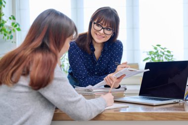 Genç kız öğrencilere dizüstü bilgisayar öğreten öğretmen. Eğitim, ergenlik, öğrenme, teknoloji, öğretim kavramı
