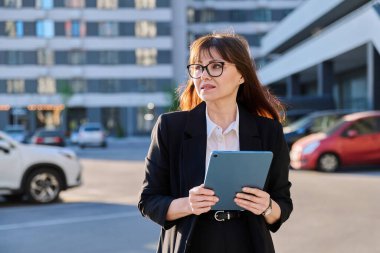 Olgun kadın yönetici profesyonel ajan girişimci iş için dijital tablet kullanıyor, modern şehir. İş elbisesi içindeki kadın lider iş kadını, açık hava, internet yazılım uygulamaları teknoloji.