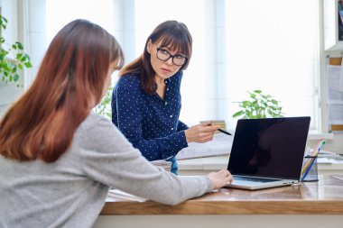 Genç kız öğrencilere dizüstü bilgisayar öğreten öğretmen. Eğitim, ergenlik, öğrenme, teknoloji, öğretim kavramı