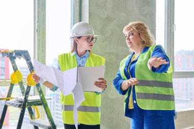 İnşaat alanında iş planlarını tartışan iki kadın sanayi işçisi. Endüstri, inşaat, inşaat, geliştirme, mimari, teknik üretim mesleklerinde kadınlar