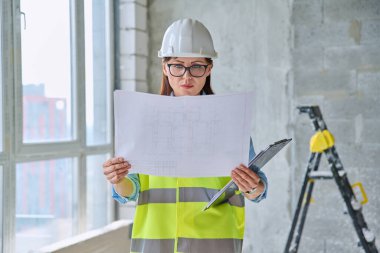 Güvenlik kasklı teknik uzman kadın inşaat işinde çalışıyor. Ciddi endüstriyel kadın mühendis müfettiş müfettişi belgeli mimar. İnşaat endüstrisi
