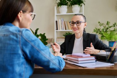 Terapist ofisinde masada oturan yetişkin bir kadınla çalışan kendine güvenen bir kadın psikolog. Psikoloji Psikoterapi Psikoterapi Terapi Danışmanlığı
