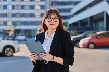 Olgun kadın yönetici profesyonel ajan girişimci iş için dijital tablet kullanıyor, modern şehir. İş elbisesi içindeki kadın lider iş kadını, açık hava, internet yazılım uygulamaları teknoloji.