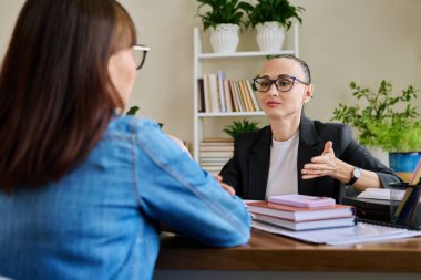 Terapist ofisinde masada oturan yetişkin bir kadınla çalışan kendine güvenen bir kadın psikolog. Psikoloji Psikoterapi Psikoterapi Terapi Danışmanlığı