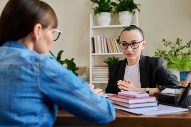 Terapist ofisinde masada oturan yetişkin bir kadınla çalışan kendine güvenen bir kadın psikolog. Psikoloji Psikoterapi Psikoterapi Terapi Danışmanlığı